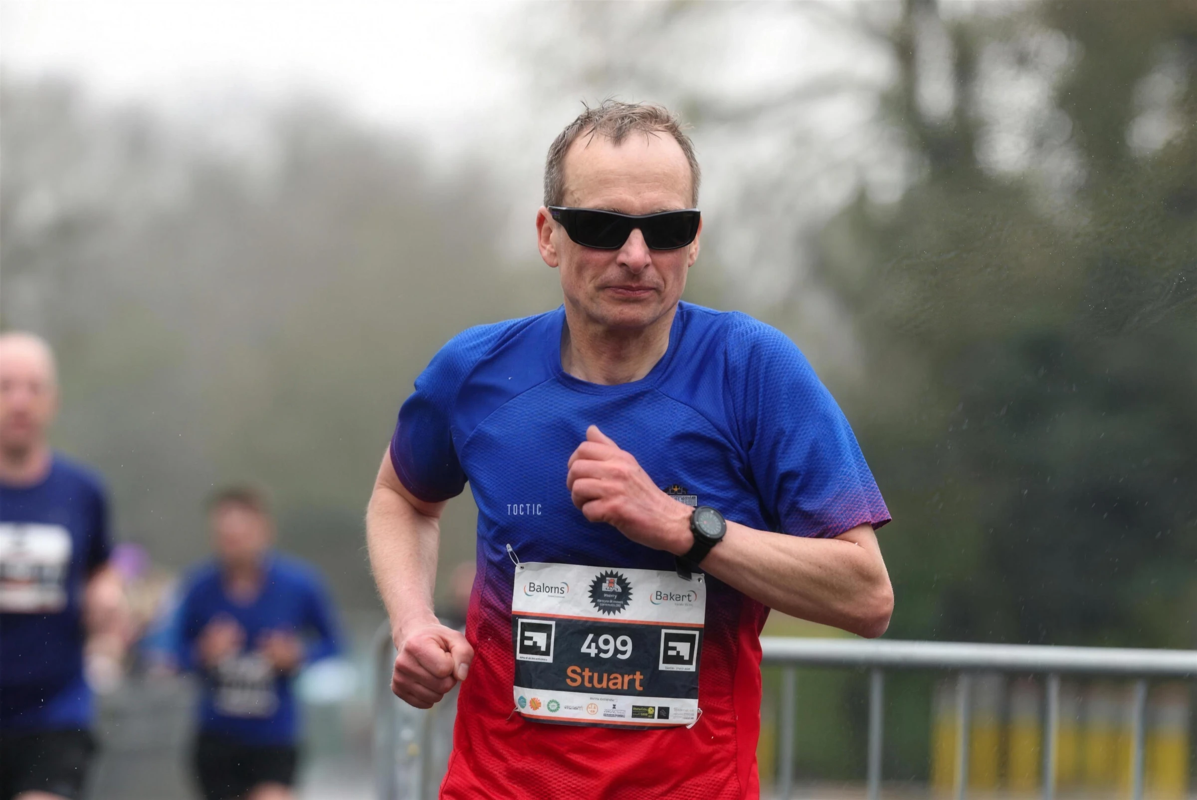 Stuart Crowther of Brentwood Beagles in sunglasses and club top racing the Brentwood Half Marathon, March 2025